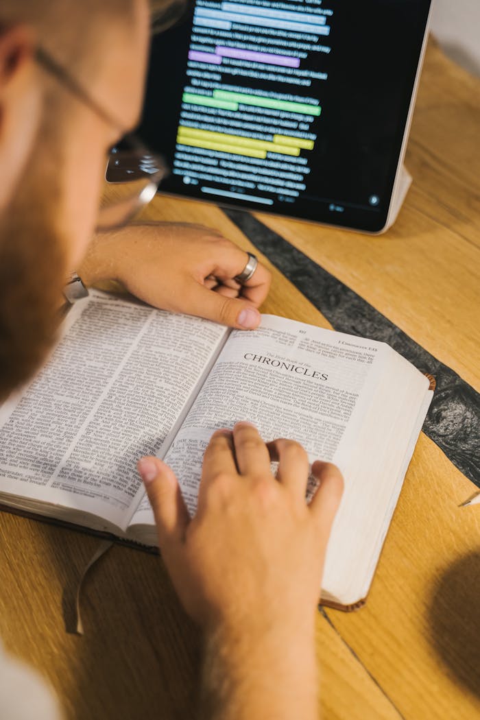 About An open Bible with Chronicles being studied, accompanied by a digital tablet for reference.